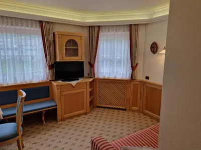 a living room with a tv and some windows at Residence Ciastel in Ortisei