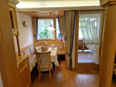 a dining room with a table and chairs and a window at Residence Ciastel in Ortisei