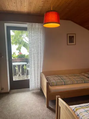 two twin beds in a room with a lamp at Haus Käfersberg in Naturno