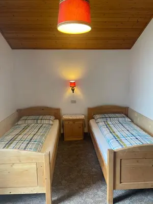 two twin beds in a room with a window at Haus Käfersberg in Naturno