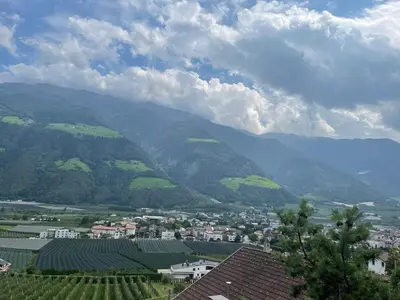 a table with food on top of a balcony with mountains at Haus Käfersberg in Naturno