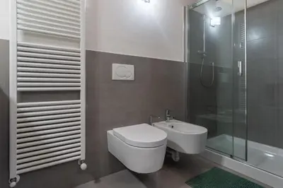 a bathroom with a toilet and a sink and a shower at Residenza Larici in Bellamonte