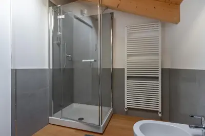 a glass shower in a bathroom with a sink at Residenza Larici in Bellamonte