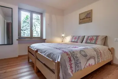 a bedroom with a bed and a window at Residenza Larici in Bellamonte