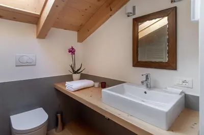 a bathroom with a sink and a toilet at Residenza Larici in Bellamonte