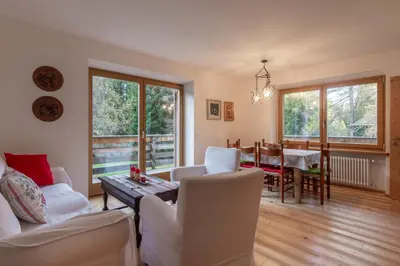 a living room with white furniture and a table at Residenza Larici in Bellamonte
