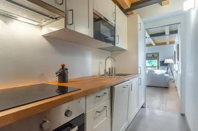 a kitchen with white cabinets and a counter top at Residenza Larici in Bellamonte