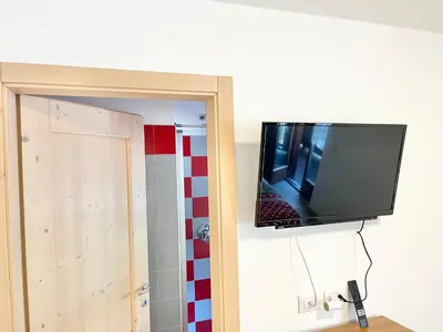 a flat screen tv hanging on a wall at CASA MARILU' in Castello di Fiemme