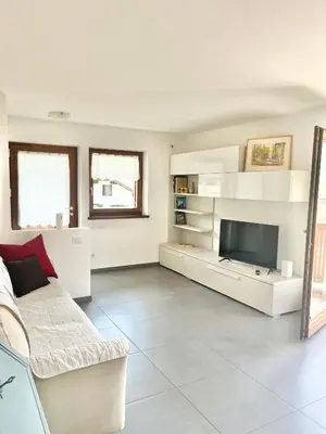 a living room with a couch and a television at CASA MARILU' in Castello di Fiemme
