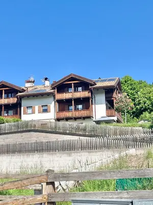 a house with a fence in front of it at CASA MARILU' in Castello di Fiemme