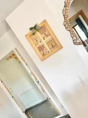 a room with a mirror and a picture on the wall at CASA MARILU' in Castello di Fiemme