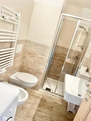 a bathroom with a shower and a toilet and a sink at CASA MARILU' in Castello di Fiemme