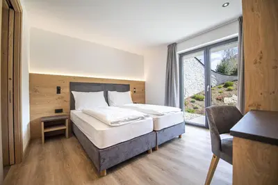 a bedroom with a bed and a large window at Apartments Chalet Silva in Selva di Val Gardena
