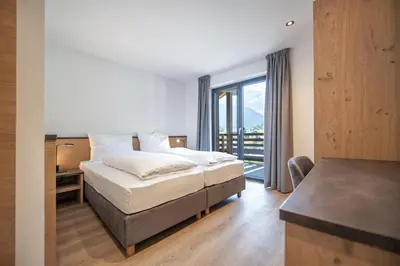 a hotel room with a bed and a balcony at Apartments Chalet Silva in Selva di Val Gardena