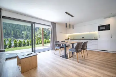 a kitchen and living room with a table and chairs at Apartments Chalet Silva in Selva di Val Gardena