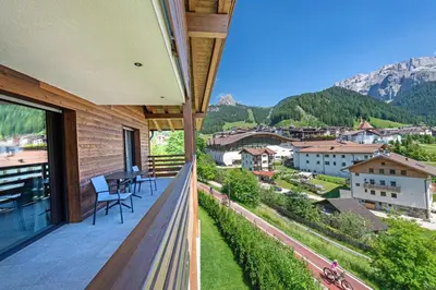 a balcony with a view of a town and mountains at Apartments Chalet Silva in Selva di Val Gardena