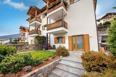 a house with balconies and a yard at Cristina Hospitality in Ortisei