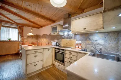 a large kitchen with wooden cabinets and a sink at Cristina Hospitality in Ortisei