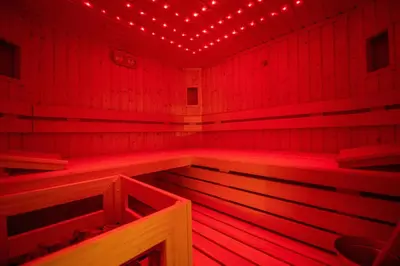 a red room with a sauna with lights on it at Cristina Hospitality in Ortisei