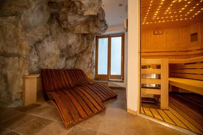 a room with a rock wall and a bench in a room at Cristina Hospitality in Ortisei