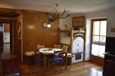 a dining room with a table and a bunk bed at Casa Amabile in San Vito di Cadore