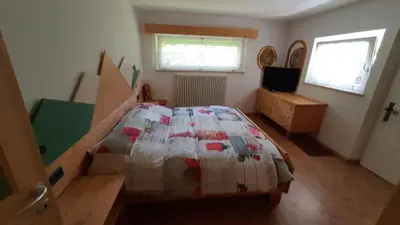 a bedroom with a bed with a quilt on it at Appartamento Zanoner Lorenzo in Moena