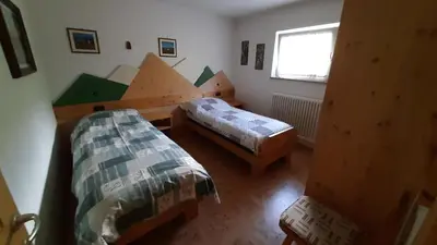 a small bedroom with two beds and a window at Appartamento Zanoner Lorenzo in Moena