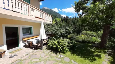 a patio with an umbrella next to a house at Appartamento Zanoner Lorenzo in Moena