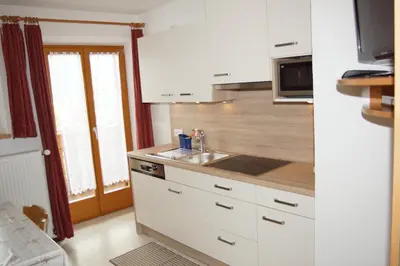 a kitchen with white cabinets and a sink at Appartment Felder Erika in Valdaora