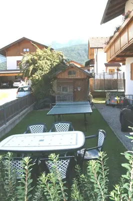 a picnic table and chairs in a yard with a house at Appartment Felder Erika in Valdaora