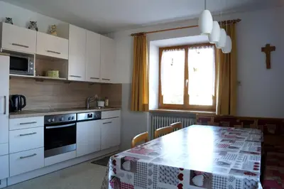 a kitchen with a table and a kitchen with white cabinets at Appartment Felder Erika in Valdaora