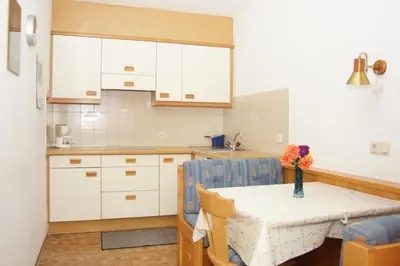 a kitchen with a table with a vase of flowers on it at Appartment Felder Erika in Valdaora