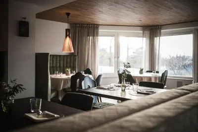 a restaurant with tables and chairs and a window at Hotel Gasthof Wieser in Petersberg