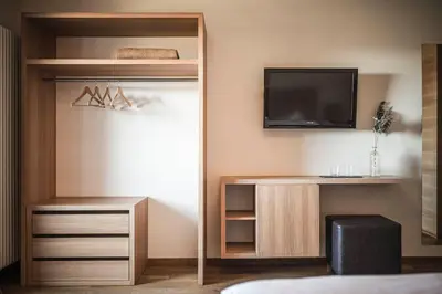 a room with a tv and a entertainment center at Hotel Gasthof Wieser in Petersberg