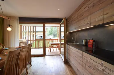 a kitchen with a counter and a table with chairs at Ciasa Lisüra in Badia