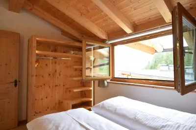 a bedroom with a bed and a window at Ciasa Lisüra in Badia