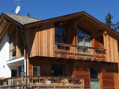 a wooden house with a balcony on the side of it at Ciasa Lisüra in Badia