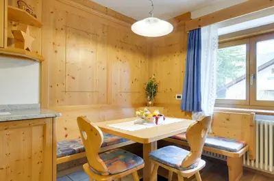 a kitchen with a table and chairs and a window at Ciasa Lisüra in Badia