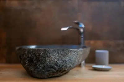 a stone sink with a faucet on a counter at Ciasa Marizana in Soraga