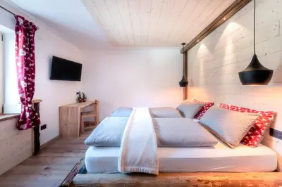 a bedroom with a bed with pillows on it at Ciasa Marizana in Soraga