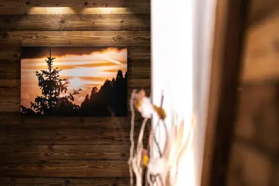 a picture of a sunset in a picture frame on a wall at Ciasa Marizana in Soraga