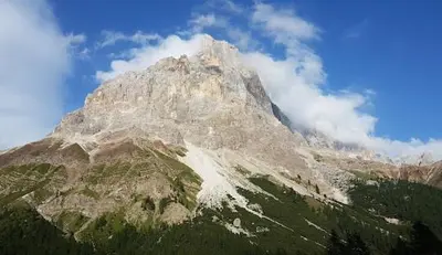 a large mountain with cloudsigunigunigunigunigunigunigunigun at Appartamento con terrazza vista Pale di San Martino in San Martino di Castrozza