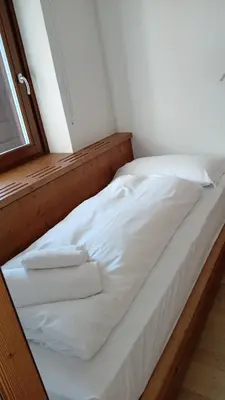 a white bed with towels on it in a room at Appartamento con terrazza vista Pale di San Martino in San Martino di Castrozza