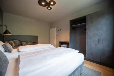 a bedroom with a large white bed and a closet at Villa Vastle in Ortisei