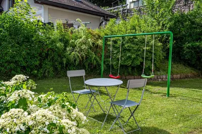 a table and two chairs and a swing in a yard at Villa Vastle in Ortisei