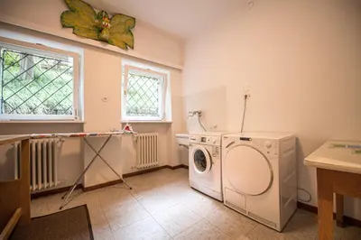 a laundry room with a washing machine and a window at Villa Vastle in Ortisei