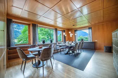 a dining room with tables and chairs and windows at Villa Vastle in Ortisei