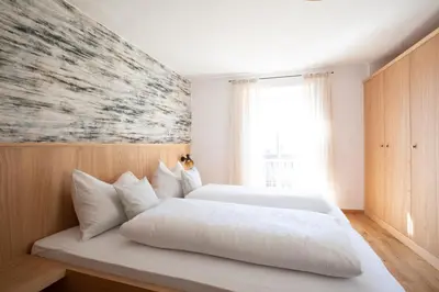 a bedroom with two white beds and a window at Weingut Pardellerhof in Marlengo