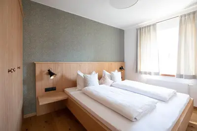 a bedroom with two beds and a window at Weingut Pardellerhof in Marlengo