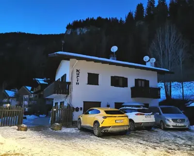 a couple of cars parked in front of a house at Casa Karin in Canazei